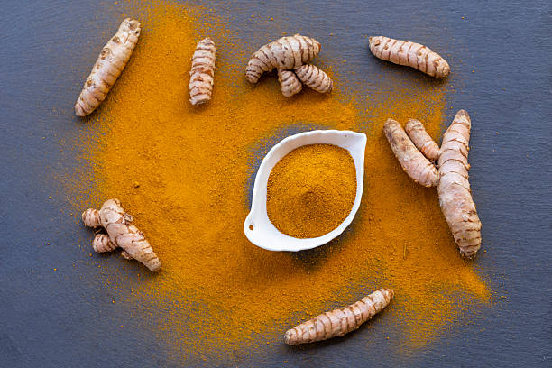 istock Fresh and ground turmeric root on a slate background 2227945236