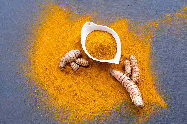 istock Fresh and ground turmeric root on a slate background 2227945241