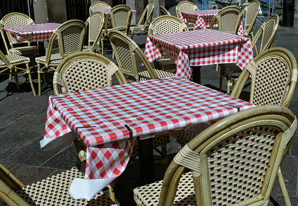 Newcastle, UK - Apr 13, 2025 - Empty tables and chairs with red and white checkered tablecloths with chairs outside a cafe on street in the afternoon. View of Outdoor summer cafe, use it as your Wallpaper, Poster and Copy space, Selective focus.