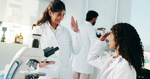 istock Science, women and high five with tablet in lab for breakthrough discovery, study success or goals. Scientists, teamwork and celebration for medical research and development of cancer immunotherapy 2227972411