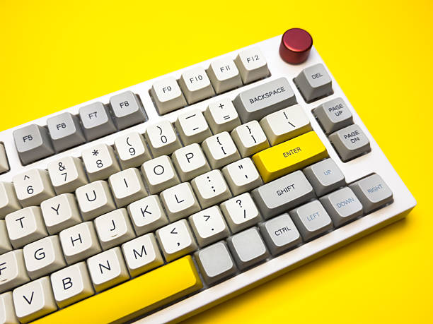 istock White mechanical keyboard with bright Enter key on bright yellow background, minimalism, keyboard buttons. A keyboard with a yellow key on the bottom left 2227972891