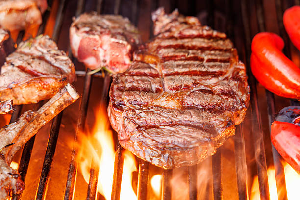 istock Juicy steaks and bell peppers sizzling on a grill 2227977010