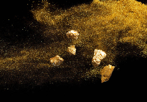 istock Explosion metallic gold glitter sparkle and gold nuggets on black background. 2227981752
