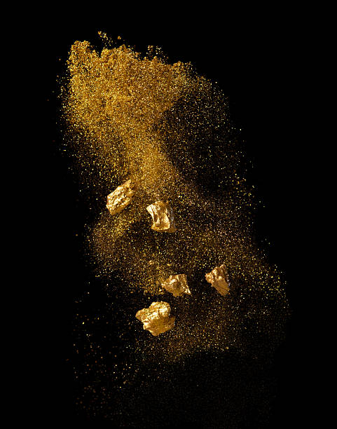 Explosion metallic gold glitter sparkle and gold nuggets on black background.