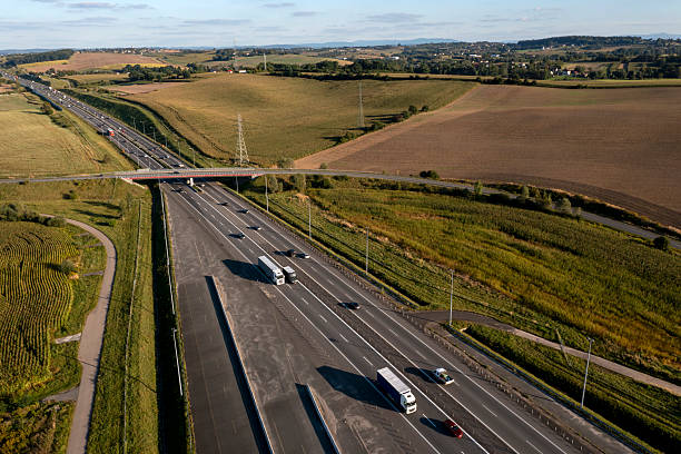 Aerial view of a highway with truck and car traffic, in a beautiful, rural, summer landscape at on a sunny afternoon.