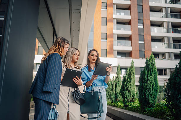 istock Businesswomen using tablet and clipboard discussing a project outside office building 2227982465