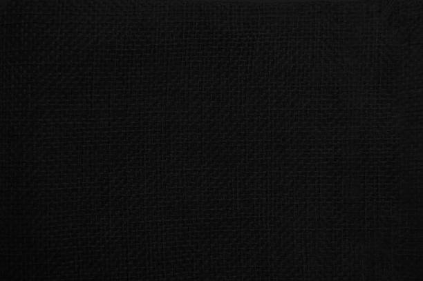 Dark black colored textured empty blank simple woven jacquard fabric material, for curtain, sofa furniture upholstery with full frame elegant weaving pattern.