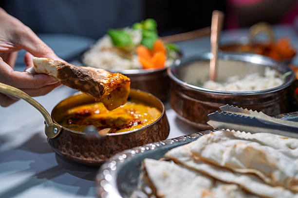 istock Hand Dipping Naan Bread into Indian Curry 2227988329