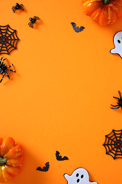 istock Happy Halloween vertical banner design. Flat lay pumpkins, spiders, ghosts, bats, and webs on orange background 2227991048