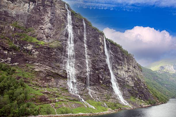 View of the Seven Sisters waterfall cascading down cliffs into the Geirangerfjord Norway seen from the water on a clear summer day