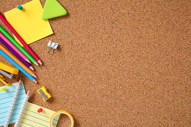 istock School stationery on cork board surface. Flat lay, top view, copy space. 2227991980