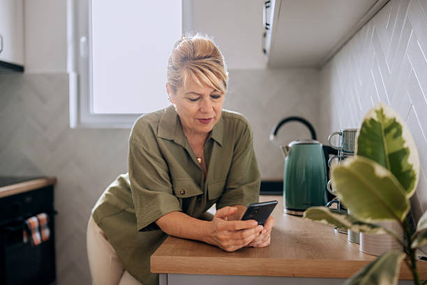istock Senior woman using phone at home 2227994852
