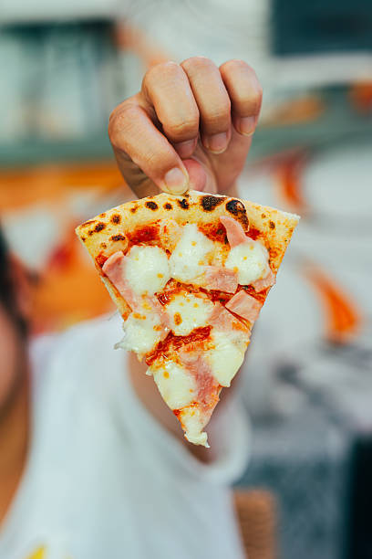 istock Hand Holding Slice of Hot Ham and Cheese Pizza 2227996982