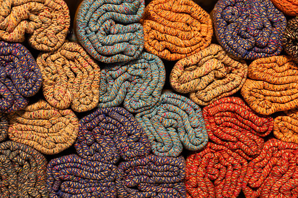 Colorful rolled textiles arranged in a visually appealing pattern showcasing vibrant hues and textures