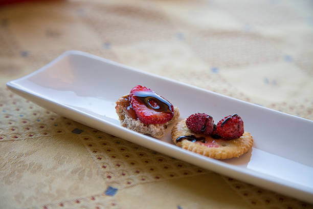 On a pristine white plate sits a delicious cracker adorned with fresh strawberries, making for an appealing and tasty treat
