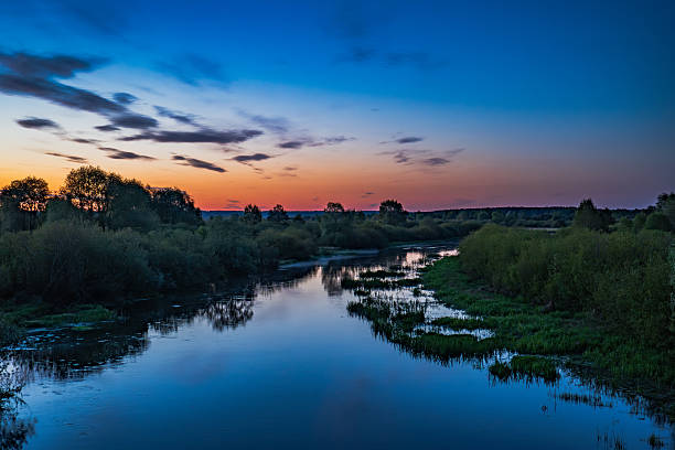 istock Dusk Over a Calm River with Lush Greenery in the Belarusian Countryside 2228005183