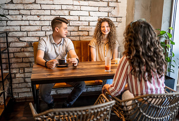 istock Young friends enjoying coffee and conversation in a cafe 2228009708