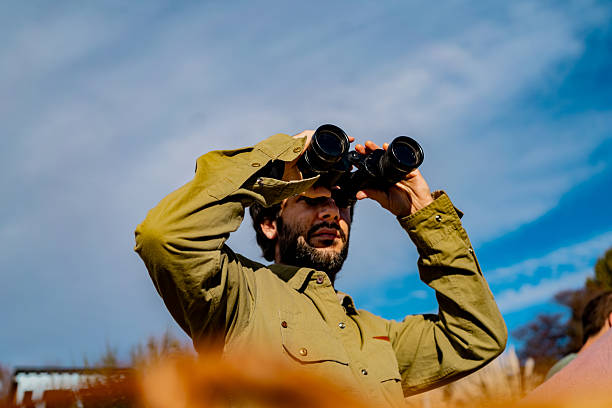 istock Mid adult man using binoculars outdoors 2228011333