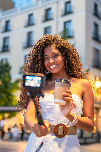 istock Young woman vlogging in the city while drinking coffee 2228018267