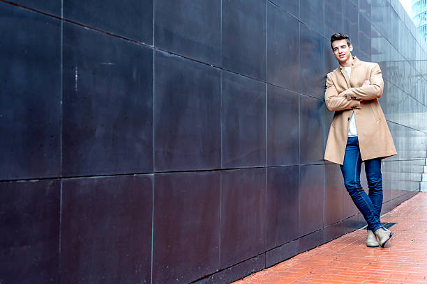 istock Stylish man leaning on wall with modern stairs 2228022694