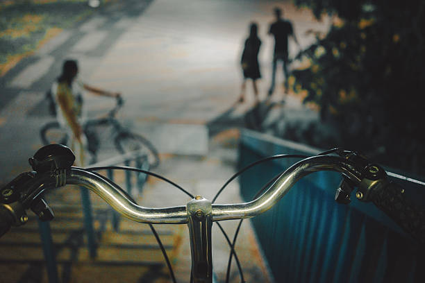 View of the bicycle handlebars on the bridge in front of the stairs, night scene.