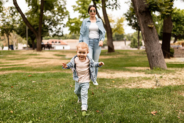 istock Little Girl Exploring Park While Mom Follows 2228027660