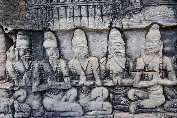 A detailed view of intricately carved stone faces at Angkor Thom, a renowned Khmer temple in Cambodia. The ancient architecture and cultural significance attract visitors seeking historical and spiritual experiences.