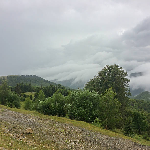 Clouds rolling over forested hills in Gorj County, Romania