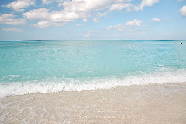 istock Clear turquoise sea with gentle waves washing onto sandy beach 2228032196