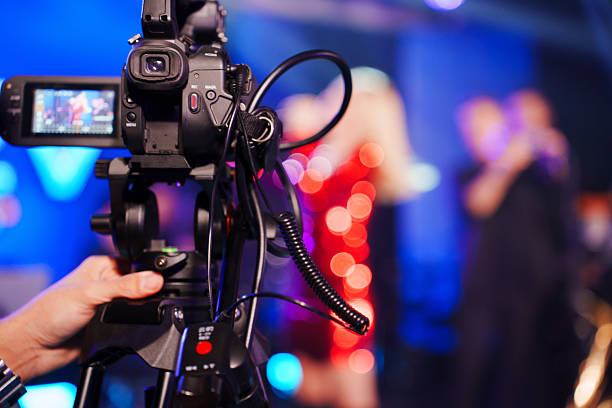 istock A professional videographer is filming a concert on stage. blurred stage. 2228036310