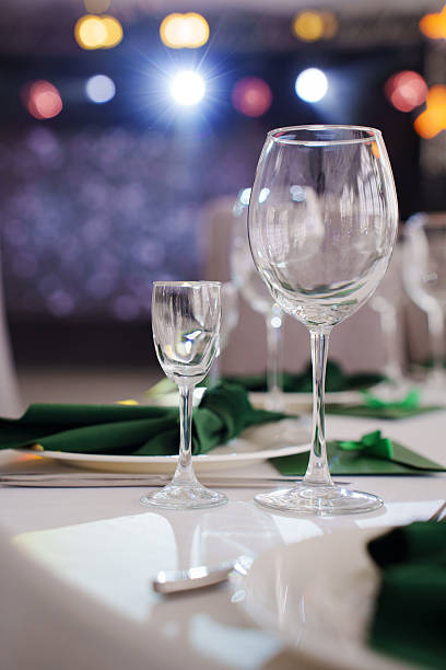 istock Setting the festive table. empty wine glasses and plates with green napkins. 2228036715