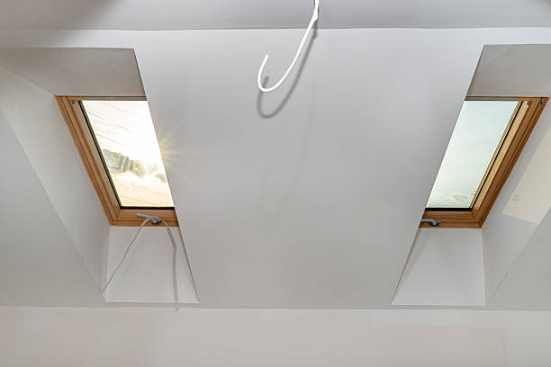 istock Attic with roof windows finished to a shell state, walls covered with plaster. 2228036882