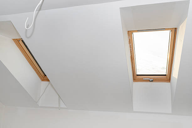 istock Attic with roof windows finished to a shell state, walls covered with plaster. 2228036896