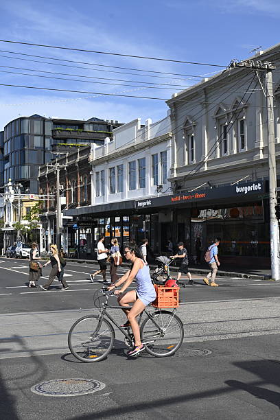 Melbourne, Australia - February 21, 2025: A cyclist rides a bike at an intersection in Collingwood, an inner-city suburb in Melbourne.