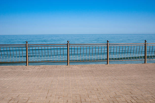 istock Empty seafront promenade with metal railings in tranquil morning 2228044454