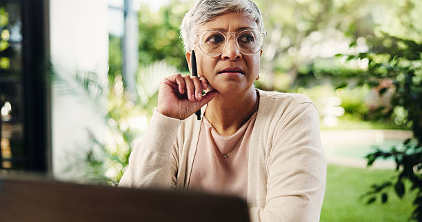 istock Thinking, remote work and serious mature woman with decision, planning lesson or course idea. Freelancer, laptop or problem solving with reflection in home backyard for education insight with teacher 2228044470