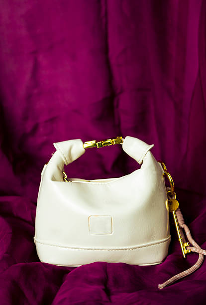 A chic brown leather handbag with a quilted design, highlighted against a serene blue background that gives the composition a calm and luxurious feel. The illumination from below casts a soft glow on the bag, emphasizing its texture and elegant form.