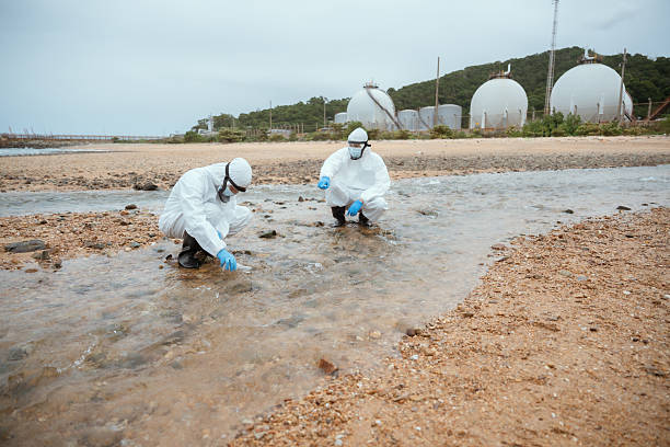 istock Two scientists collect water samples on a beach near industrial facilities during a cloudy day for environmental research purposes 2228046745