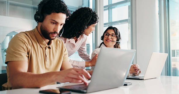 istock Typing, representative and man with laptop, call center and coworkers with headset for consultation. Online, agent and people with tech for telemarketing, lead generation and sales on web in office 2228047100