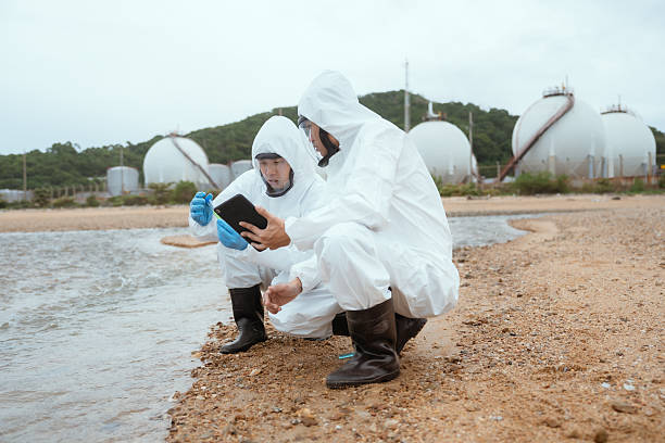 istock Scientists biologists and researchers in protective suits taking water samples from waste water from industrial. Experts analyze the water in a contaminated environment. 2228047912