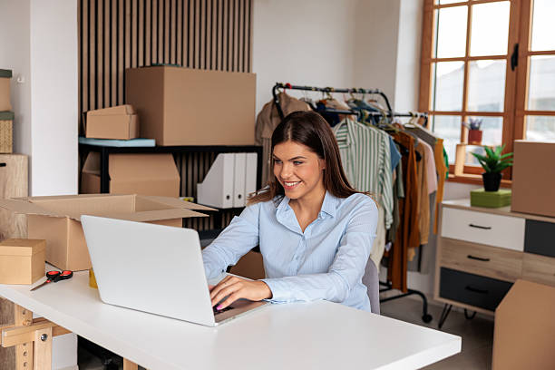 istock Woman Working on Laptop with Shipping Boxes in Home Office 2228055210
