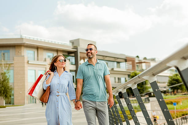 istock Couple enjoys a sunny afternoon stroll while shopping in a vibrant urban setting at a modern shopping complex 2228061408