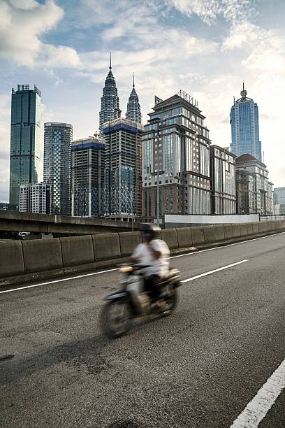 Man riding a motorcycle near the city centre highway at Kuala Lumpur, Malaysia