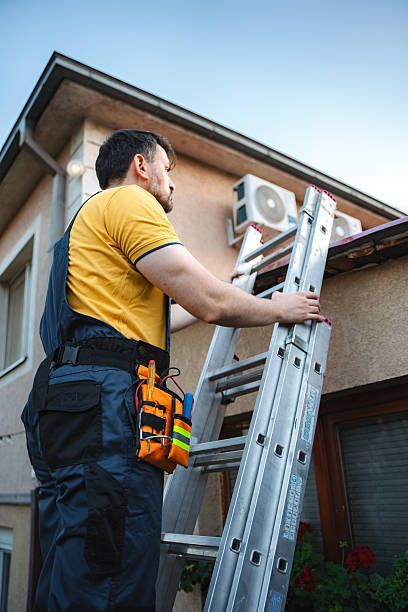 istock Technician climbing a ladder and installing an air conditioner on a building facade 2228065486