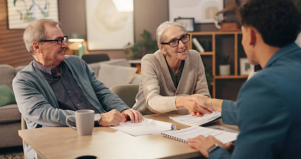 istock Elderly couple, documents and handshake with financial advisor for retirement plan at home. Senior man, woman and shaking hands with accountant or paperwork for pension fund or application at house 2228065505