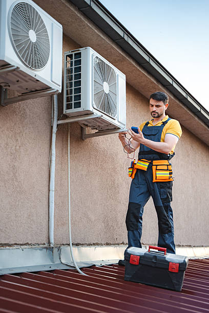 Technician installing and checking air conditioning unit on the roof