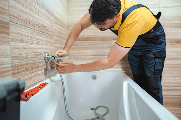 istock Plumber Installing Faucet on Bathtub in Bathroom 2228065754