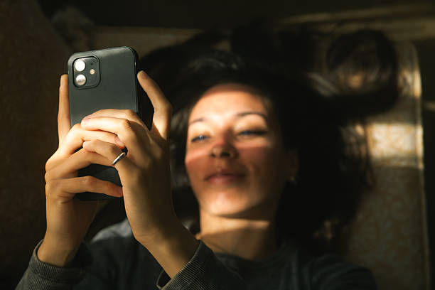 istock Woman Relaxing with Smartphone in Sunlight 2228068323