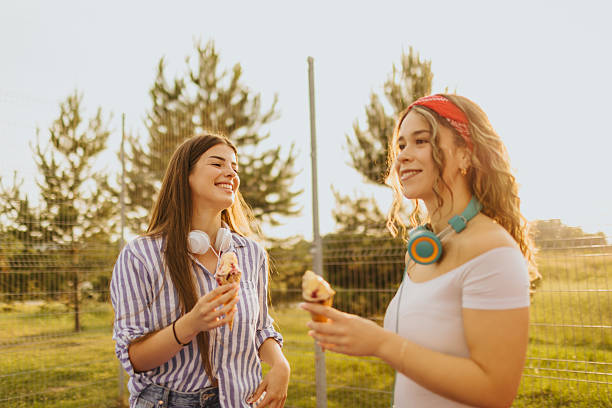 istock Girlfriends enjoying ice-cream while roller skating together 2228071338