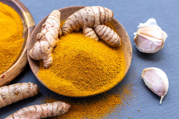 istock Fresh and ground turmeric root on a slate background 2228072962